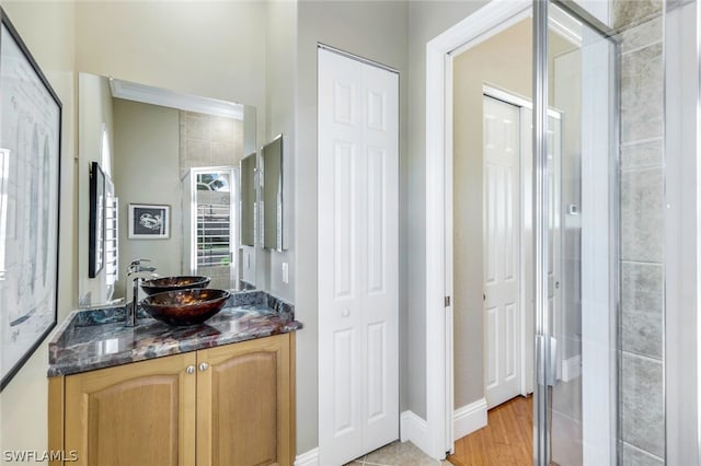 full bathroom featuring a tile shower and vanity