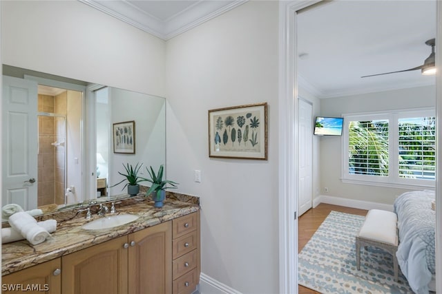 full bathroom featuring baseboards, ornamental molding, wood finished floors, and vanity