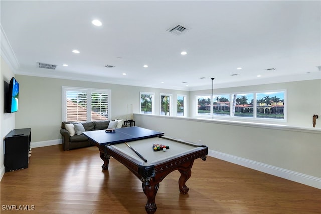 recreation room featuring baseboards, crown molding, visible vents, and wood finished floors