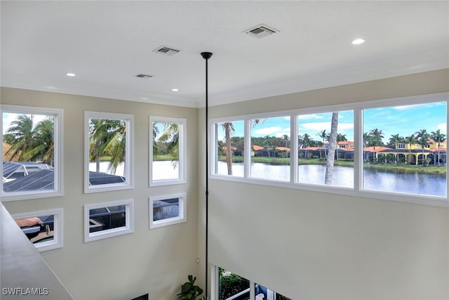 details featuring ornamental molding, recessed lighting, visible vents, and a water view