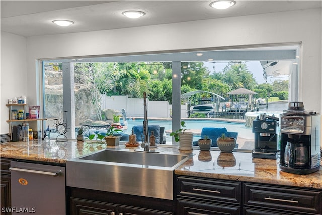 kitchen with light stone countertops and stainless steel dishwasher