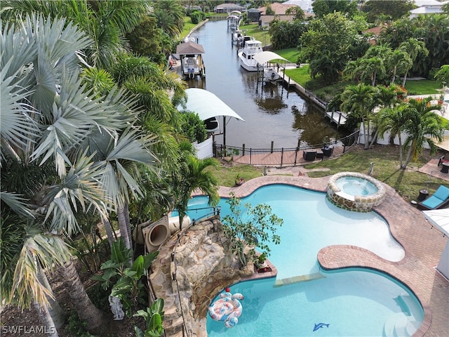 view of pool with a water view, a patio area, and an in ground hot tub