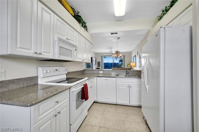 kitchen with light tile floors, sink, white appliances, white cabinetry, and kitchen peninsula