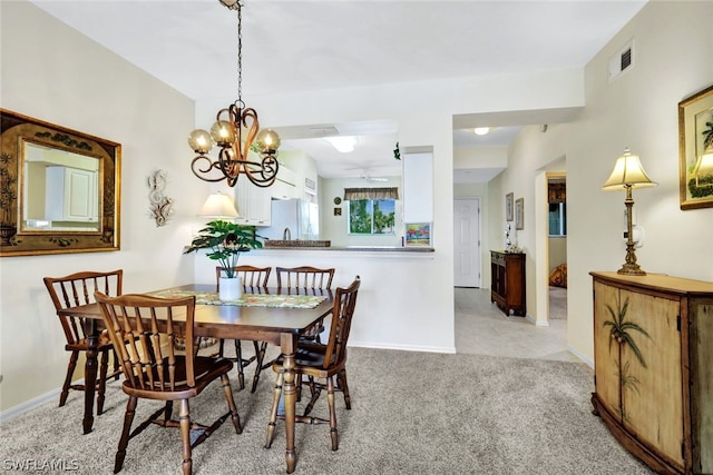 carpeted dining space with an inviting chandelier