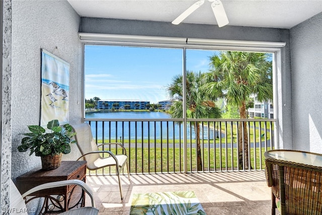 sunroom / solarium with ceiling fan and a water view