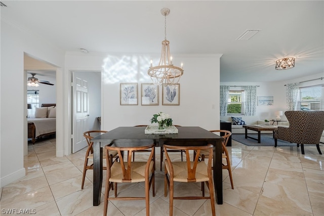 dining area featuring ceiling fan with notable chandelier and crown molding