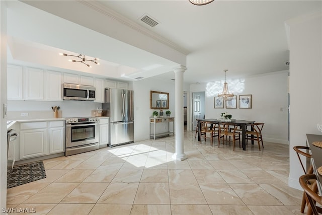 kitchen with ornate columns, stainless steel appliances, decorative light fixtures, a notable chandelier, and white cabinetry