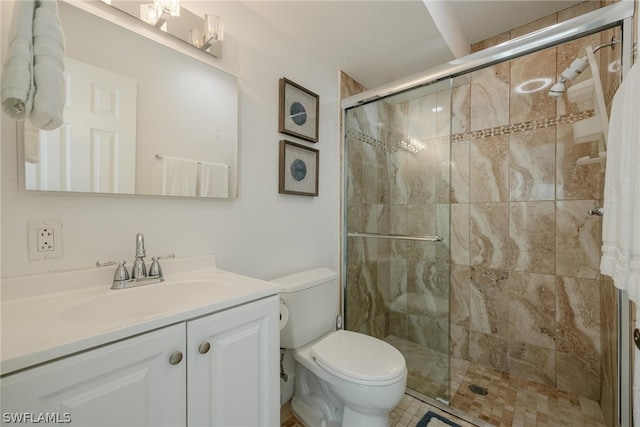 bathroom featuring tile patterned floors, vanity, toilet, and a shower with shower door