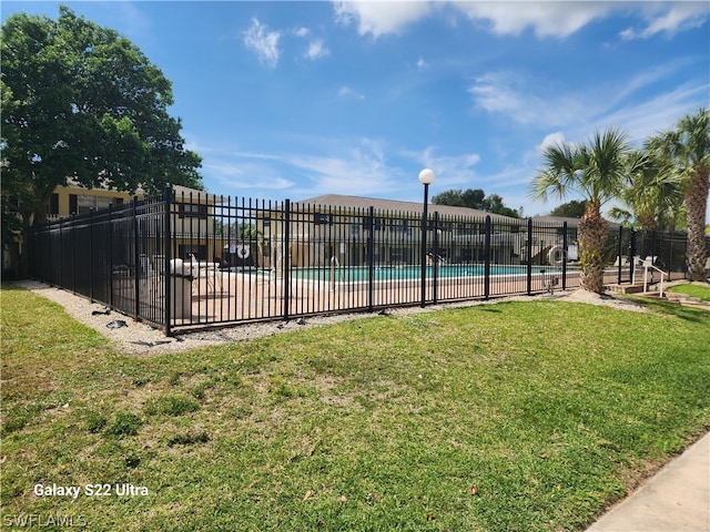 view of swimming pool featuring a yard