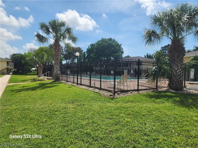 view of swimming pool featuring a lawn