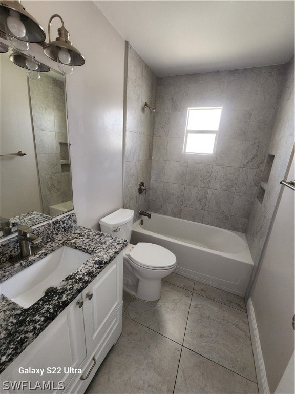 full bathroom with tile floors, toilet, vanity, and tiled shower / bath combo