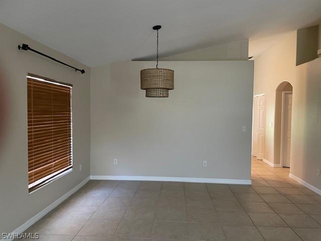 tiled spare room with lofted ceiling