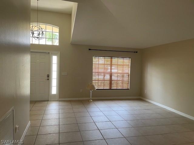 foyer with a chandelier and light tile patterned floors