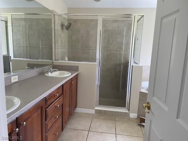 bathroom with tile patterned flooring, vanity, and an enclosed shower