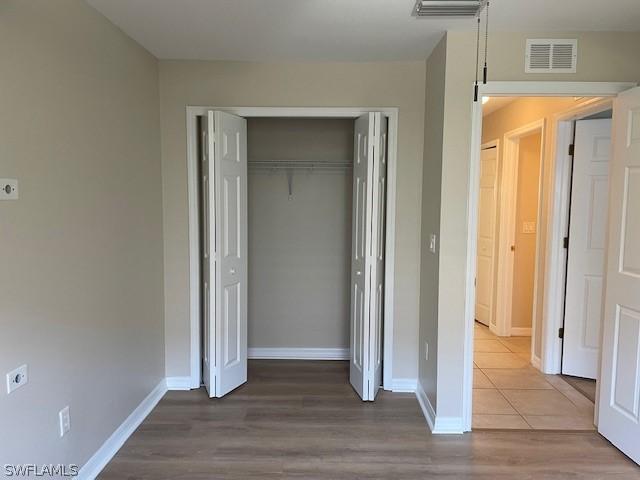 unfurnished bedroom featuring hardwood / wood-style flooring and a closet