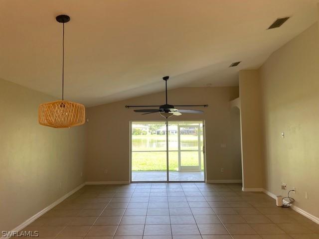 spare room with ceiling fan, light tile patterned flooring, and lofted ceiling