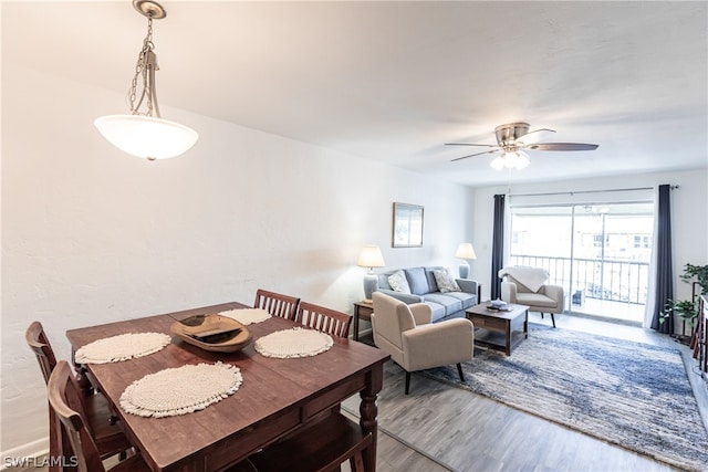 dining space with ceiling fan and light hardwood / wood-style flooring