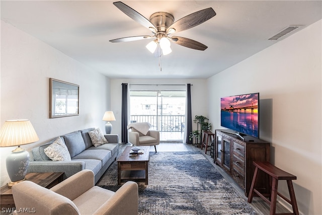 living room with ceiling fan and dark hardwood / wood-style flooring