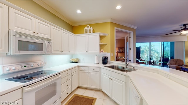 kitchen with white appliances, sink, kitchen peninsula, white cabinets, and crown molding