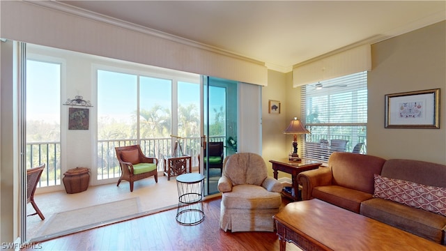 living room with a healthy amount of sunlight, ornamental molding, and hardwood / wood-style floors