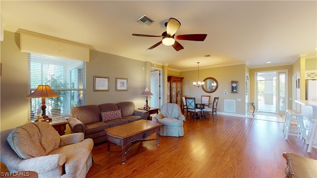 living room with crown molding, hardwood / wood-style flooring, and ceiling fan with notable chandelier