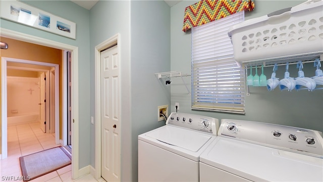 laundry room with independent washer and dryer, a healthy amount of sunlight, and light tile patterned floors