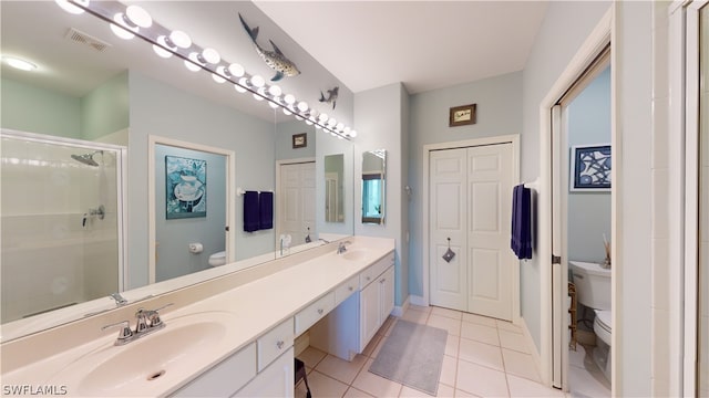 bathroom featuring a shower with door, vanity, toilet, and tile patterned flooring