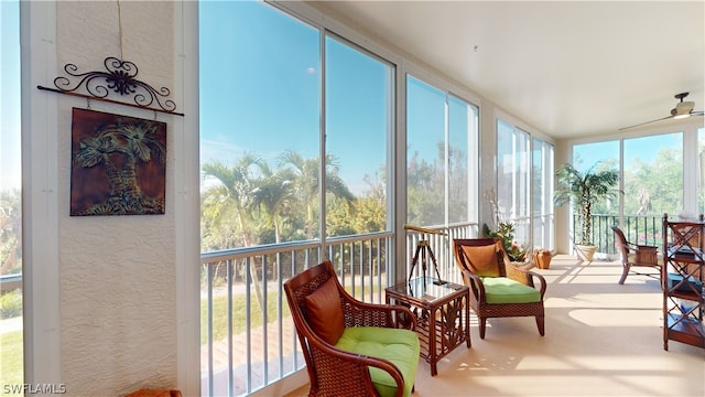 sunroom / solarium with a fireplace and ceiling fan