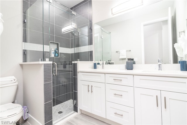 full bath featuring double vanity, a stall shower, a sink, and toilet