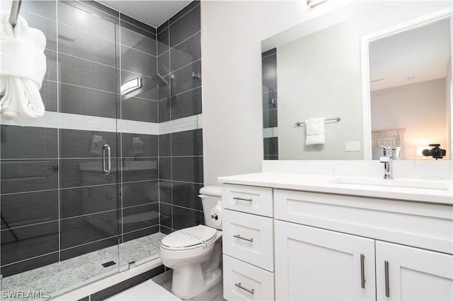 bathroom with a shower stall, vanity, and toilet