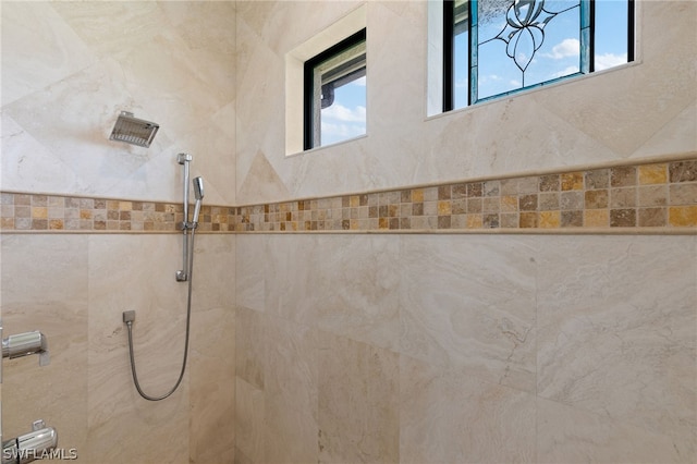 bathroom featuring a tile shower and plenty of natural light