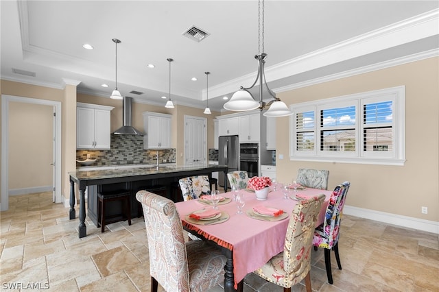 dining area featuring a raised ceiling and ornamental molding