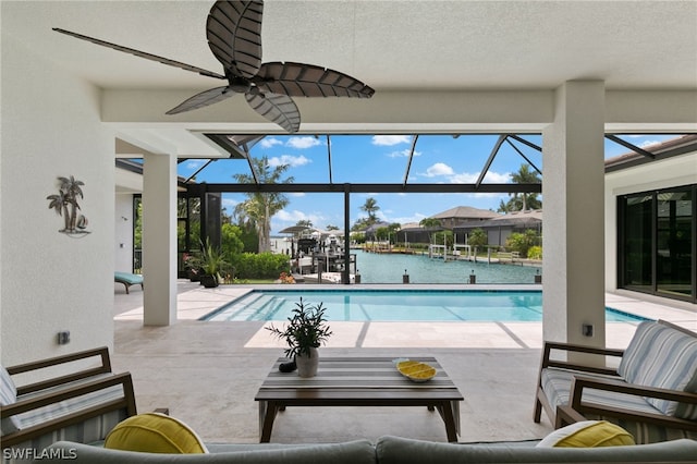 view of swimming pool featuring ceiling fan and a water view