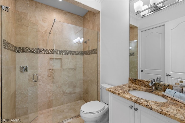 bathroom featuring vanity, a shower with shower door, and toilet