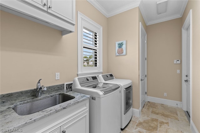 clothes washing area with separate washer and dryer, crown molding, sink, and cabinets