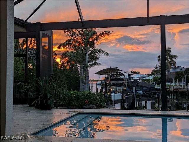 pool at dusk with a patio area