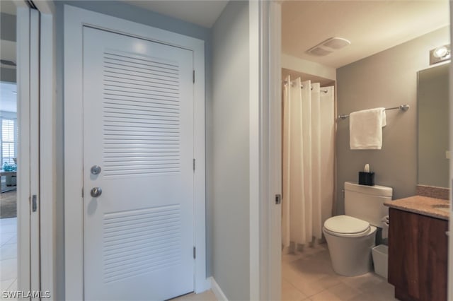 bathroom featuring toilet, tile flooring, and vanity