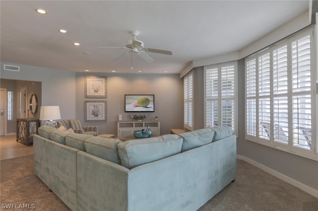 carpeted living room with ceiling fan