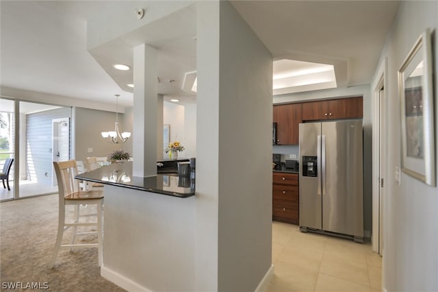 kitchen featuring hanging light fixtures, light tile flooring, a notable chandelier, a kitchen bar, and stainless steel fridge with ice dispenser