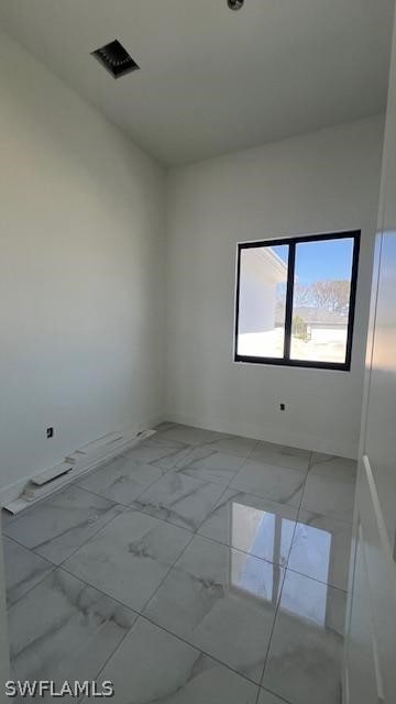 unfurnished room with light tile flooring