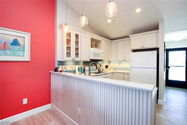 kitchen with kitchen peninsula, white appliances, and decorative light fixtures