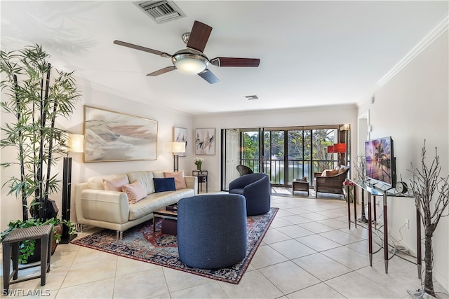 living room with ceiling fan, ornamental molding, and light tile floors