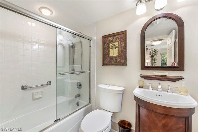 full bathroom with bath / shower combo with glass door, toilet, and vanity