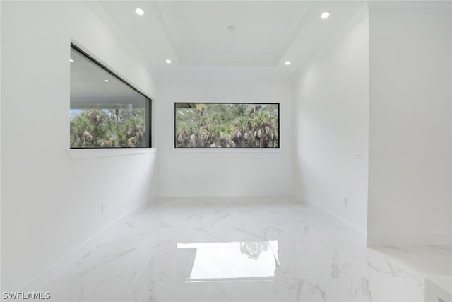 tiled spare room featuring a tray ceiling and ornamental molding