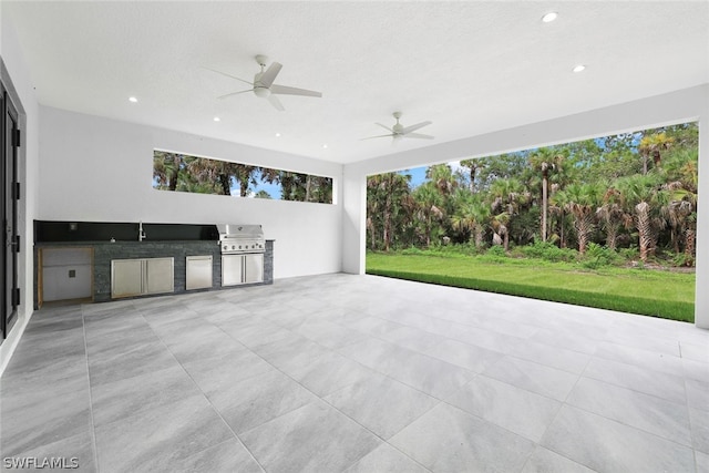 view of patio / terrace with ceiling fan, a grill, and exterior kitchen