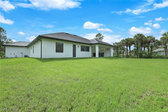 rear view of house featuring a yard