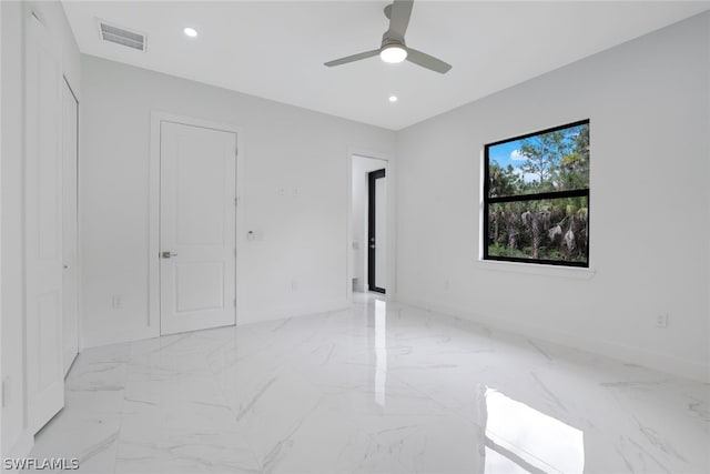 tiled spare room featuring ceiling fan