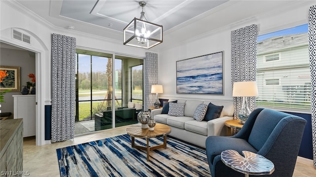 tiled living room featuring plenty of natural light, a tray ceiling, and a notable chandelier