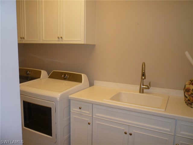 laundry area with washer and clothes dryer, cabinets, and sink