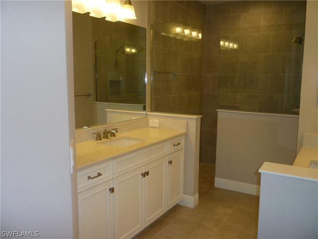 bathroom featuring tile flooring, tiled shower, and vanity